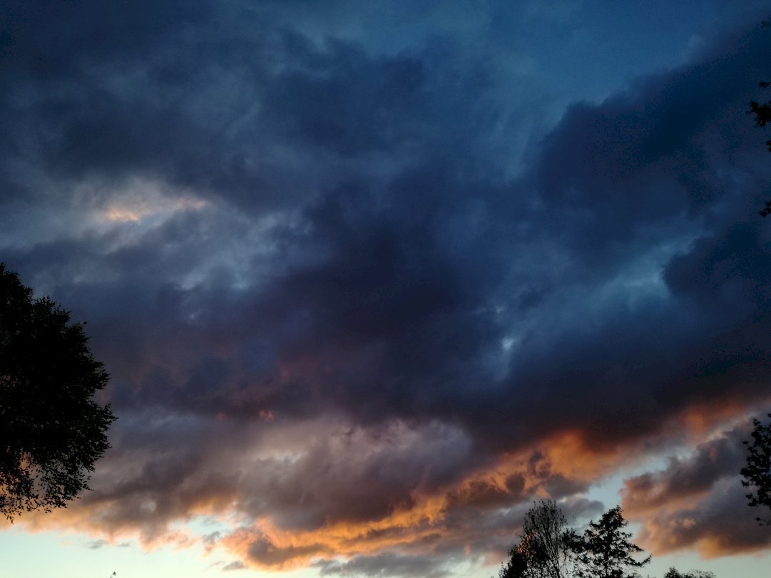 a sky with dark-clouds while the sun is going under